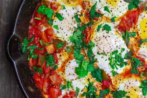 Simple Shakshuka Recipe | The Mediterranean Dish. Shakshuka is a delicious Middle Eastern dish of eggs poached in a spiced, saucy tomato stew. Perfect for breakfast, lunch or dinner! All you need to add is your favorite bread. This is a simple vegetarian recipe that you can make in less than 30 minutes! My family's favorite. And feeds a crowd on a small budget. See the recipe on TheMediterraneanDish.com