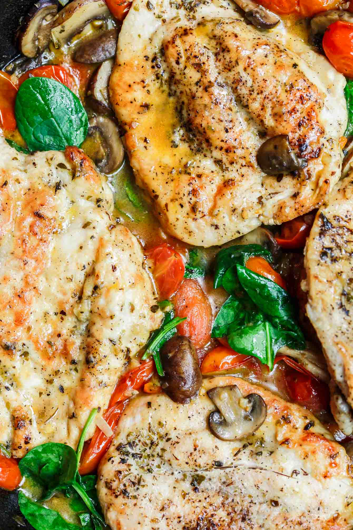 30-Minute Italian Skillet Chicken Recipe with Tomatoes and Mushrooms | The Mediterranean Dish. Flavor packed chicken breasts cooked in white wine with mushrooms, tomatoes and more! The perfect weeknight dinner in minutes! See the recipe on TheMediterraneanDish.com